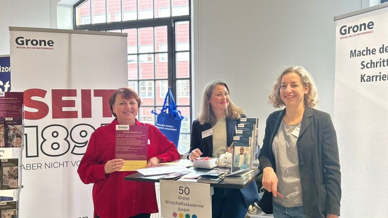 Das Bild zeigt Mitarbeitende der Grone-Wirtschaftsakademie am Messe-Stand